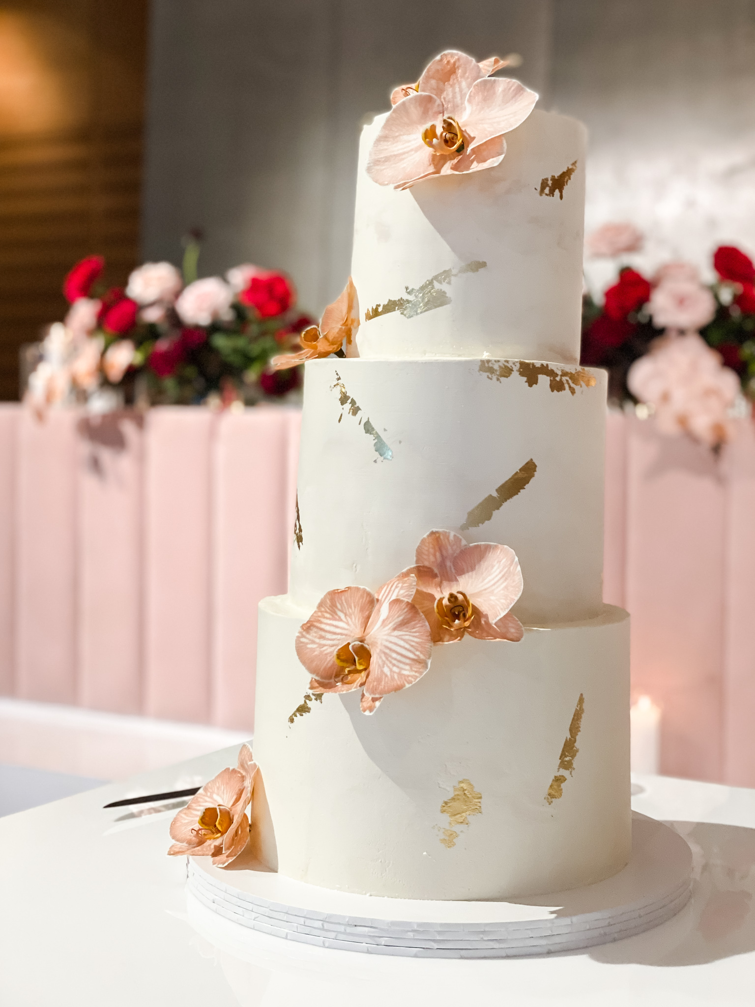Three tier white wedding cake with gold leaf and fresh florals for contemporary Indian wedding at Zinc at Fed Square, Melbourne
